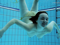 Молоденькая брюнетка сняла купальный костюм плавая в бассейне
